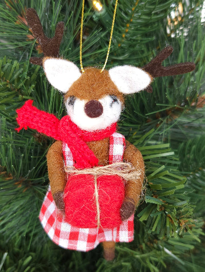 Decorative deer ornament with a red scarf and gift on a Christmas tree.
