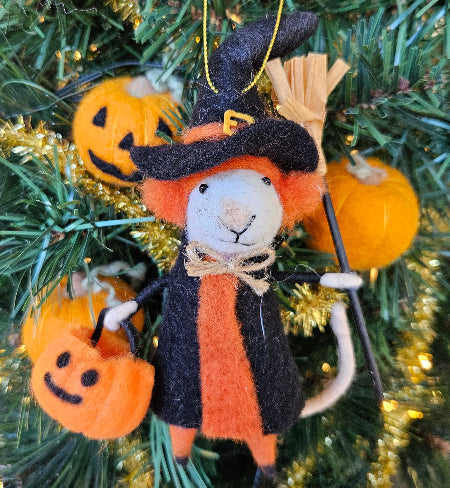 Halloween-themed ornament with a mouse in a witch costume on a decorated tree.