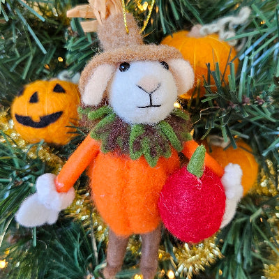 Decorative Christmas ornament of a rabbit in a pumpkin outfit on a tree.