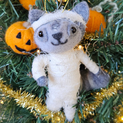 Bandanged raccoon ornament on a decorated Christmas tree with Jack-o-Lanterns