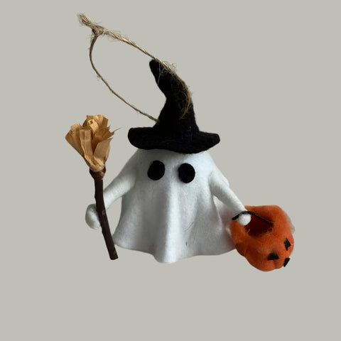 Halloween-themed decoration with ghost, broom, and pumpkin on a white background