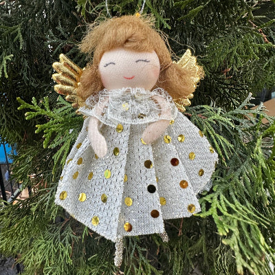 Decorative angel fairy figurine with gold accents on a Christmas tree.