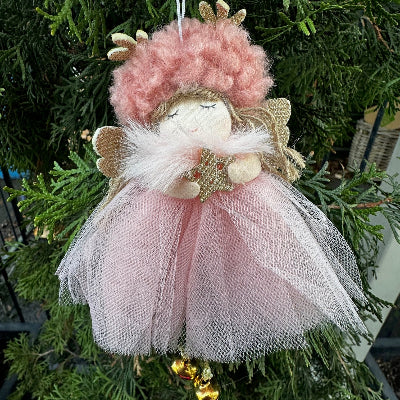 Decorative angel ornament with pink and gold details on a Christmas tree.