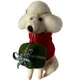 White felted poodle dog Christmas decoration holding a red heart and green bag with a bow on a light gray background