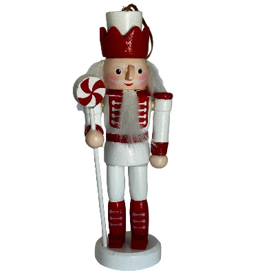 Decorative nutcracker figure with red and white details on a plain background