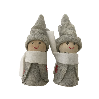 Two Christmas decorations made of wood and felt, one standing upright and the other lying flat, both with white scarves and red hats.